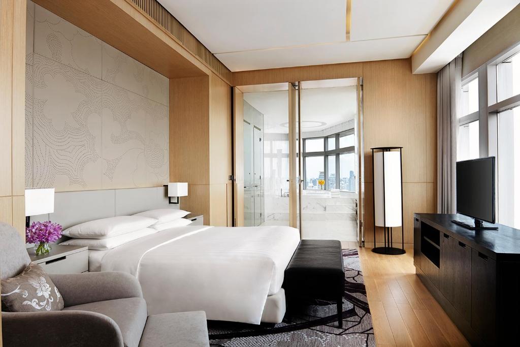 a bedroom with a large bed and a television at Bangkok Marriott Hotel Sukhumvit in Bangkok