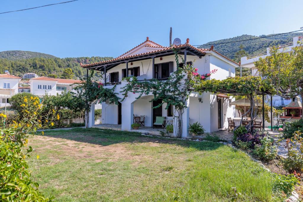 a white house with a yard in front at Studios Elpiniki in Skopelos Town