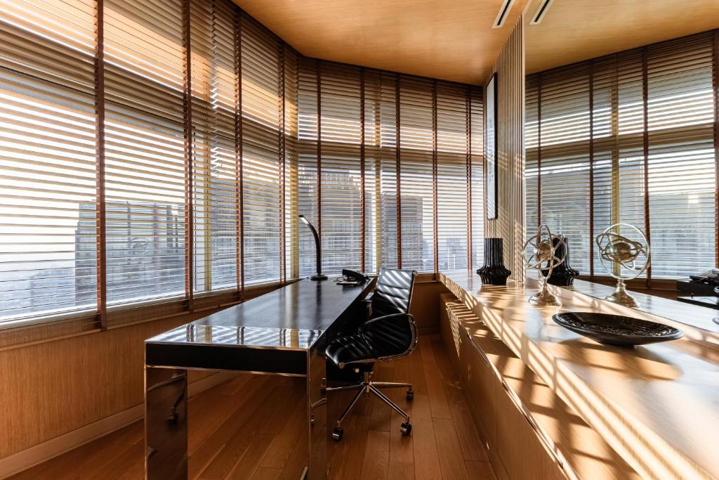 an office with a desk with a chair and windows at Bangkok Marriott Hotel Sukhumvit in Bangkok