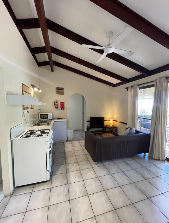 una cucina e un soggiorno con piano cottura e divano di Wildsights Villas a Denham