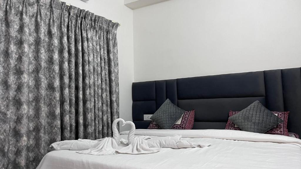 a bedroom with a bed with a black headboard at Mithila - A Lovely & Peaceful 3 BHK Villa in Orchha