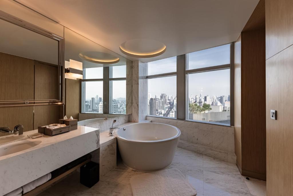 a bathroom with a large tub and a large window at Bangkok Marriott Hotel Sukhumvit in Bangkok