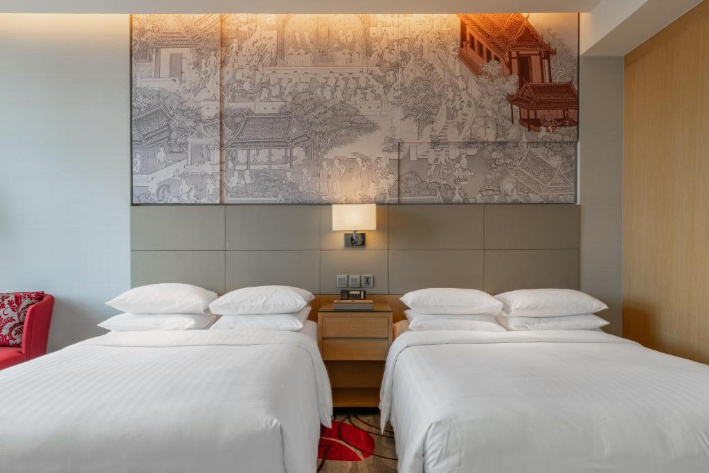 two beds in a hotel room with a map on the wall at Bangkok Marriott Hotel Sukhumvit in Bangkok