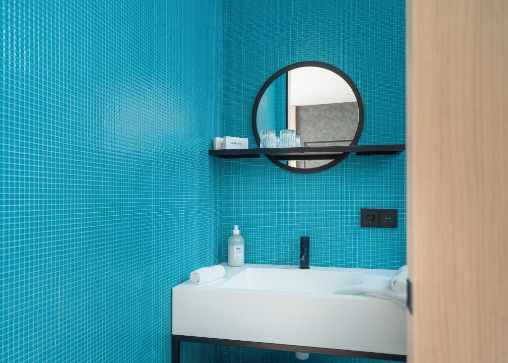 un bagno con un lavandino bianco e uno specchio di Hotel Lotus a Reykjavik