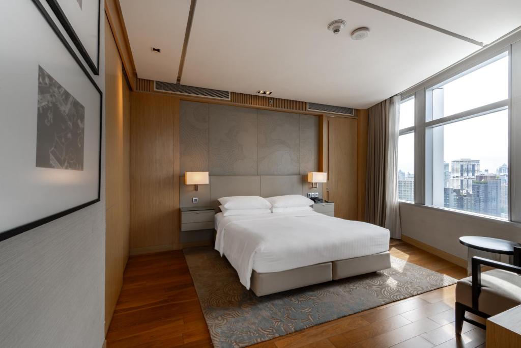 a bedroom with a white bed and a large window at Bangkok Marriott Hotel Sukhumvit in Bangkok