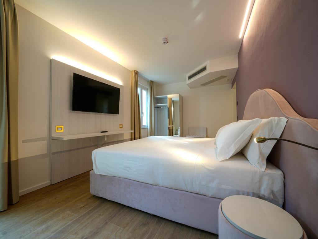 a hotel room with a bed and a television at Castiglioncello Suite in Castiglioncello