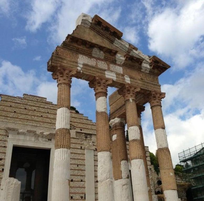 un tempio con colonne di fronte a un edificio di Capitolium Ad a Brescia