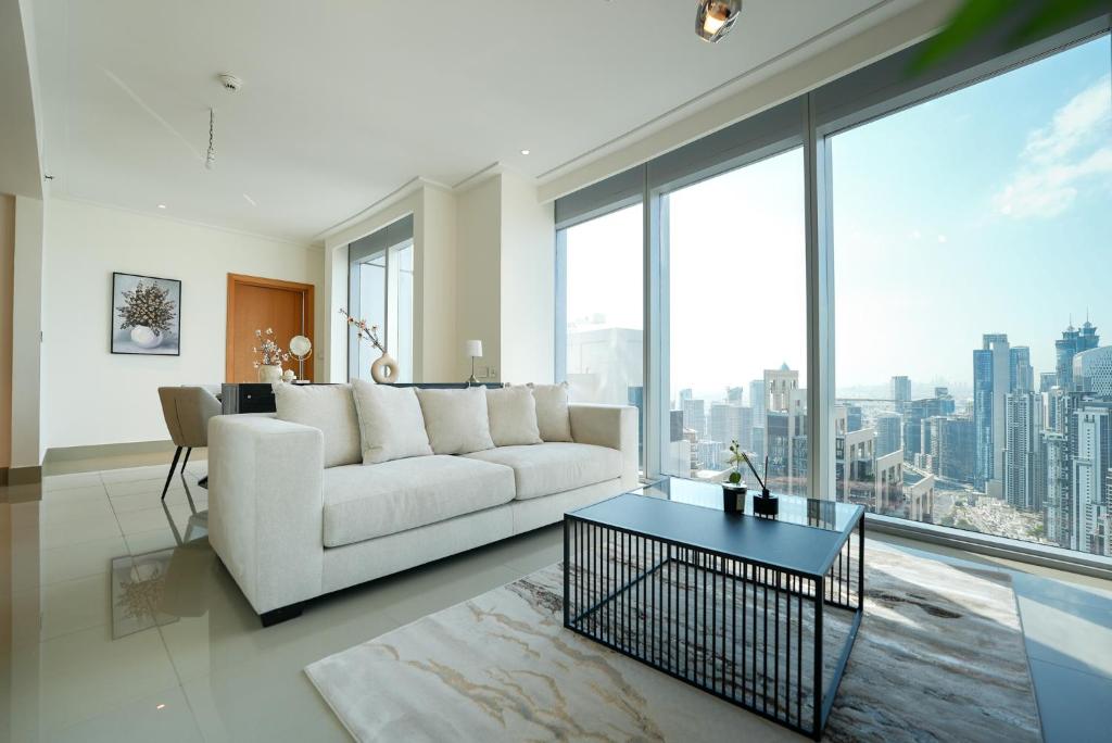 a living room with a white couch and large windows at Luxurious 1BR in Opera Grand 5 mins walk to Burj Khalifa in Dubai