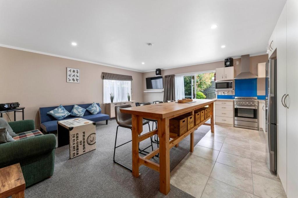 a kitchen and living room with a table and a couch at Hilltop Hideaway in Taupo