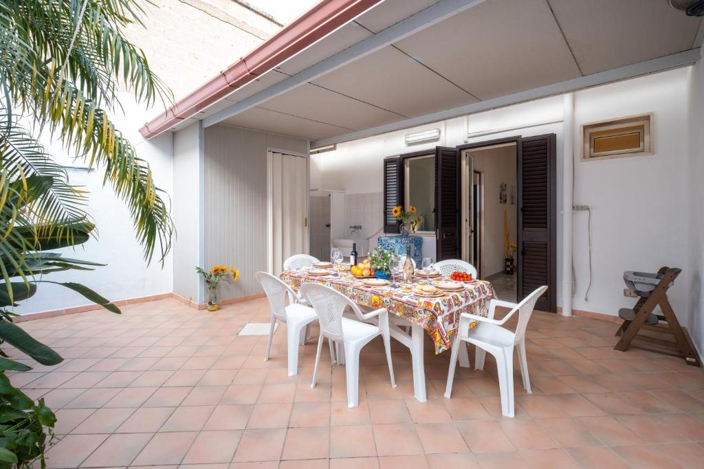 a dining room table and chairs on a patio at Villetta Fronte Mare White Beach in Porto Cesareo