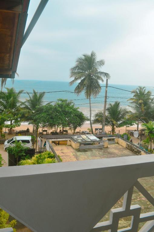 a view of a beach with palm trees and the ocean at Glow Accommadation in Tangalle