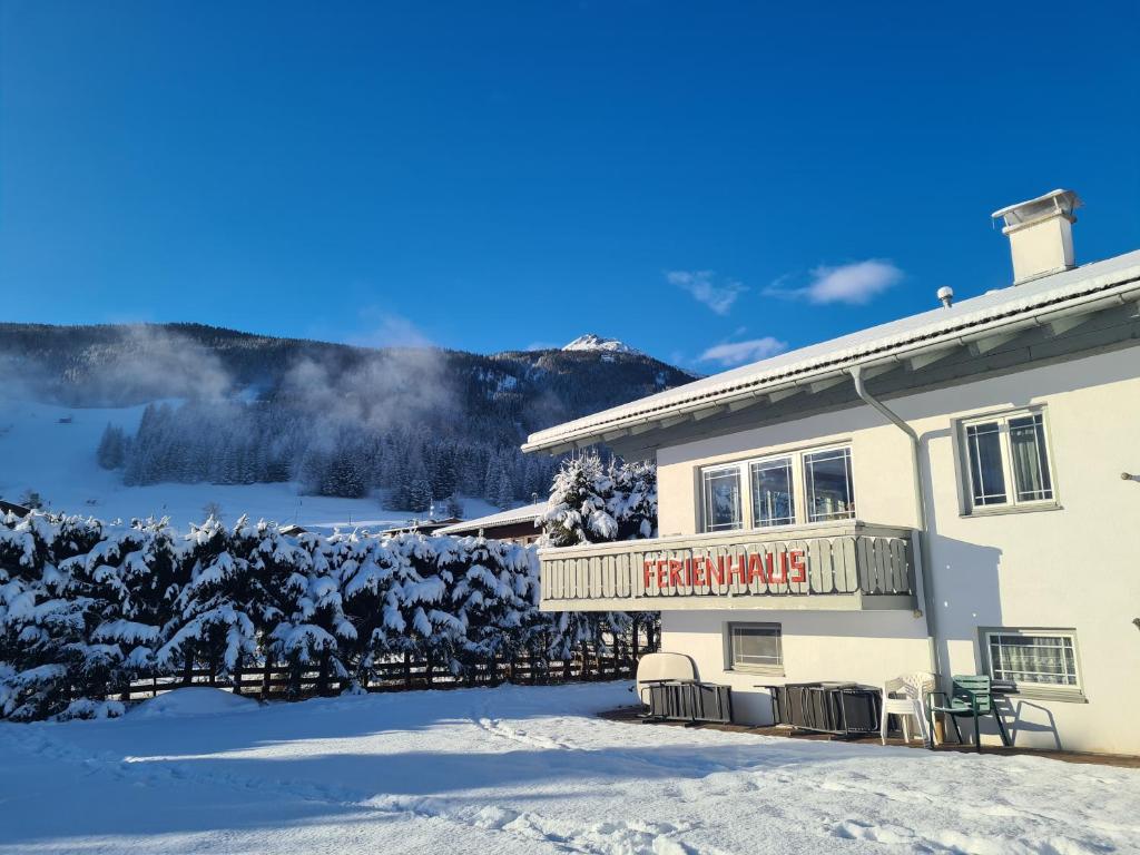 a building with a sign on it in the snow at Marlene's Ferienhaus in Lermoos