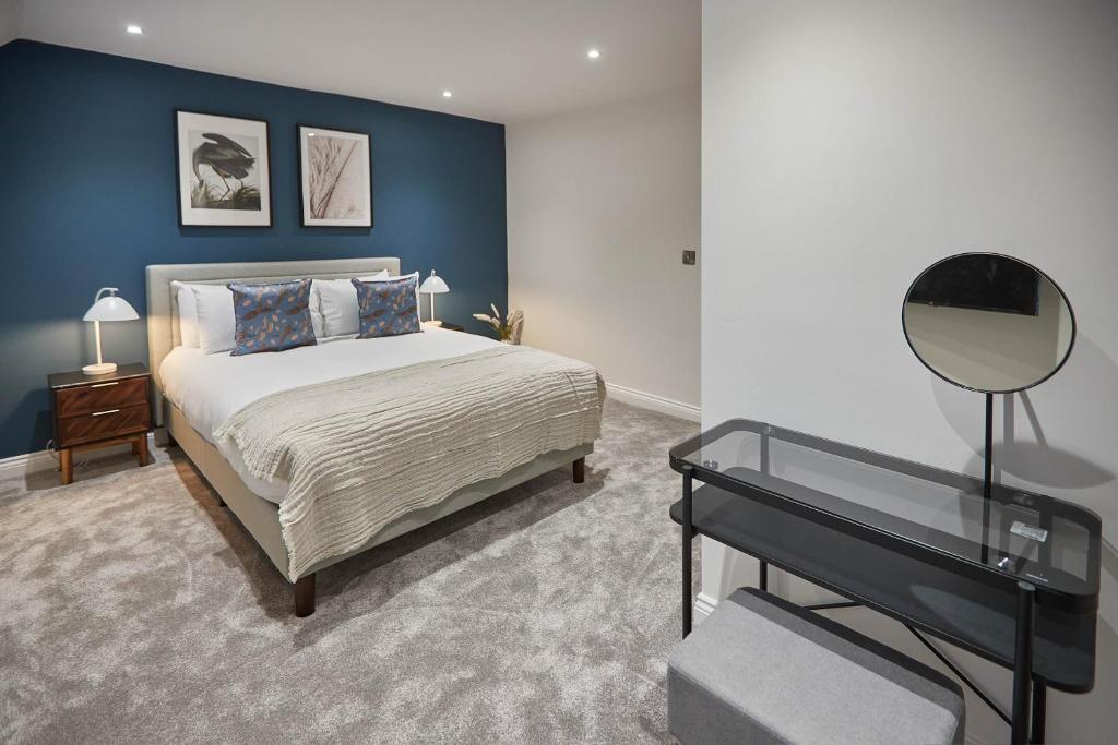 1 dormitorio con 1 cama extragrande y espejo en Host & Stay - Iburn House, en Sleights