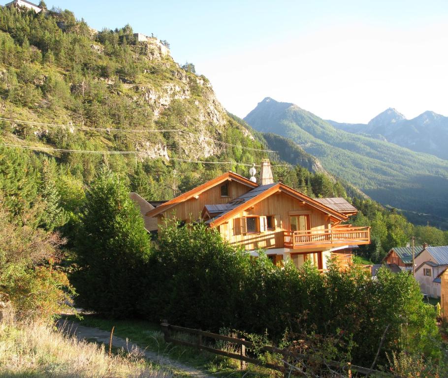 a house on a hill with mountains in the background at Chalet de l'Orceyrette in Briançon