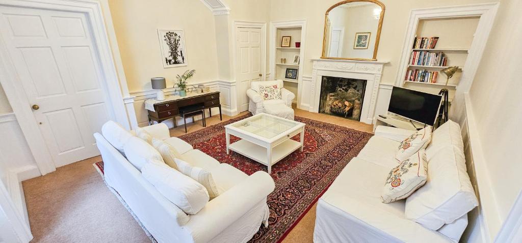 a living room with white furniture and a fireplace at Russel House - 4 Bedroom - The Royal Mile in Edinburgh