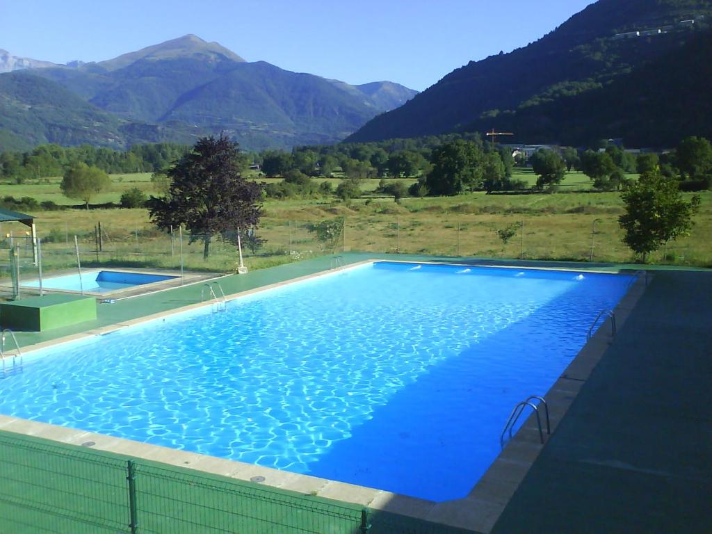 una gran piscina azul con montañas en el fondo en Pinarillos, en Sarvisé