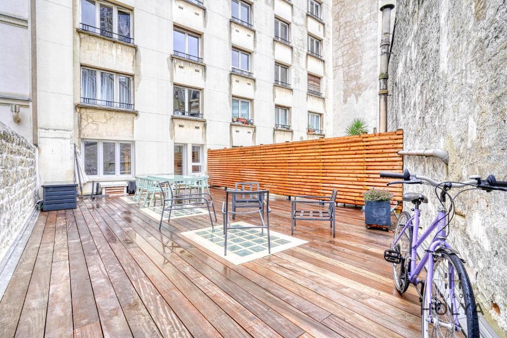 un vélo garé sur une terrasse en bois devant un bâtiment dans l'établissement Proche Porte Maillot - Le Patio - 393B, à Neuilly-sur-Seine