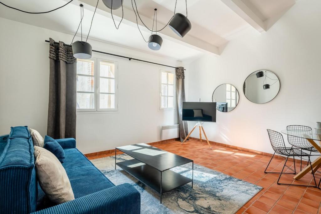 ein Wohnzimmer mit einem blauen Sofa und einem Tisch in der Unterkunft Grand Duplex T2 - Plein coeur historique et du port in Marseille