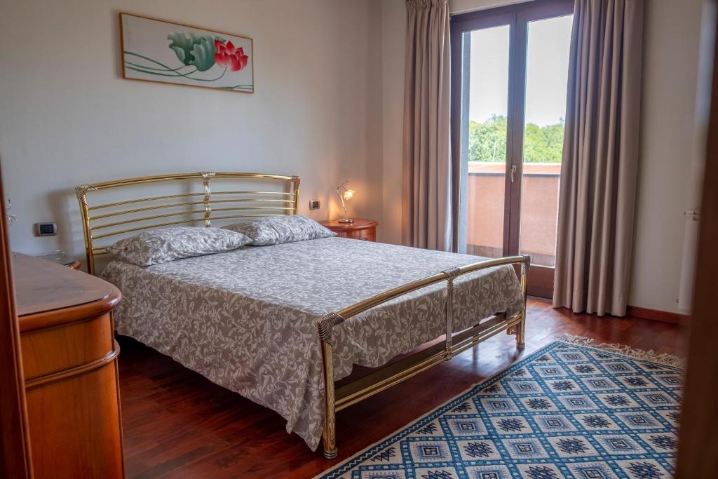 une chambre avec un lit et une grande fenêtre dans l'établissement Villa Etna da mare, à Fleri