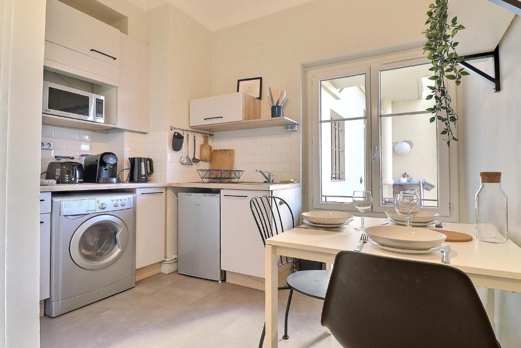 une cuisine avec une table et une machine à laver dans l'établissement Modern and Cozy Studio in the Heart of Perrache Lyon, à Lyon