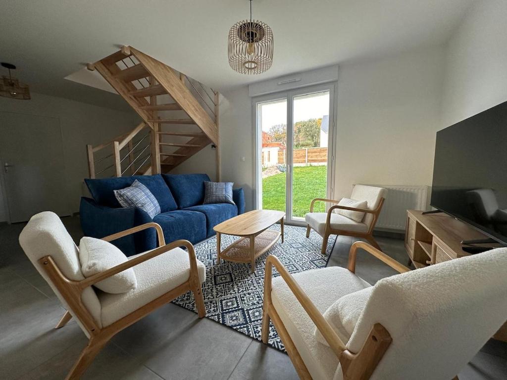 un salon avec un canapé bleu et des chaises dans l'établissement La Brise Marine, à Barneville-Carteret