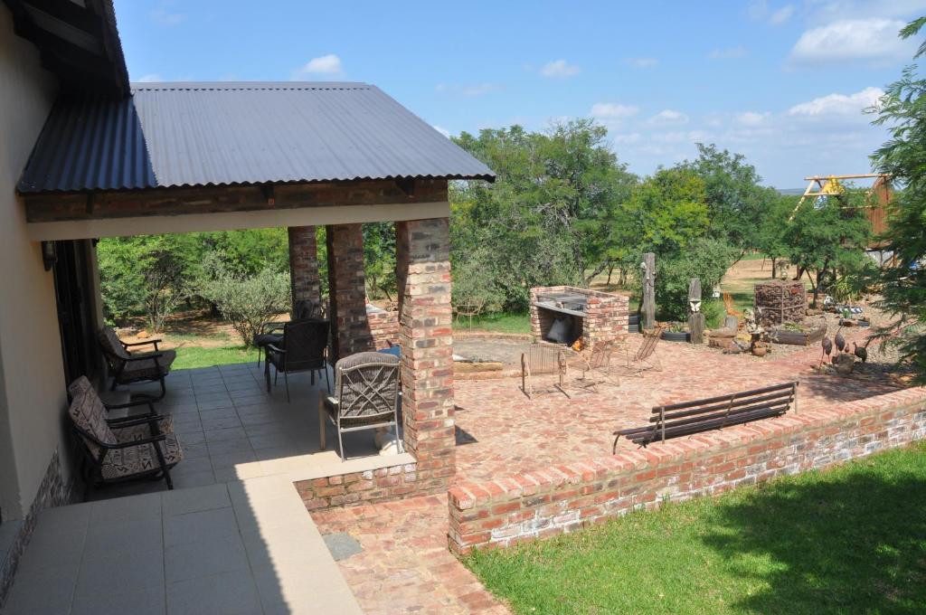 a brick patio with a fireplace in a yard at Thorntree Lodge in Potchefstroom