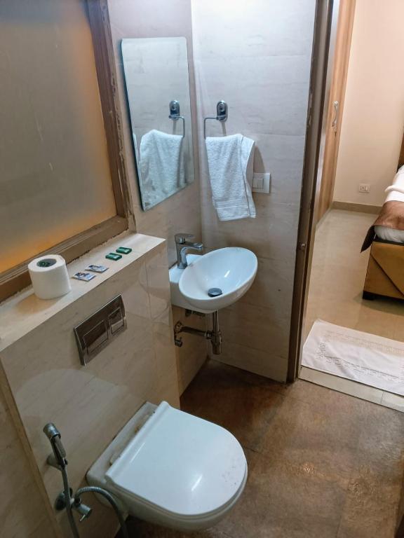 un bagno con un water bianco e un lavandino di Soooper Hotel a Gurgaon