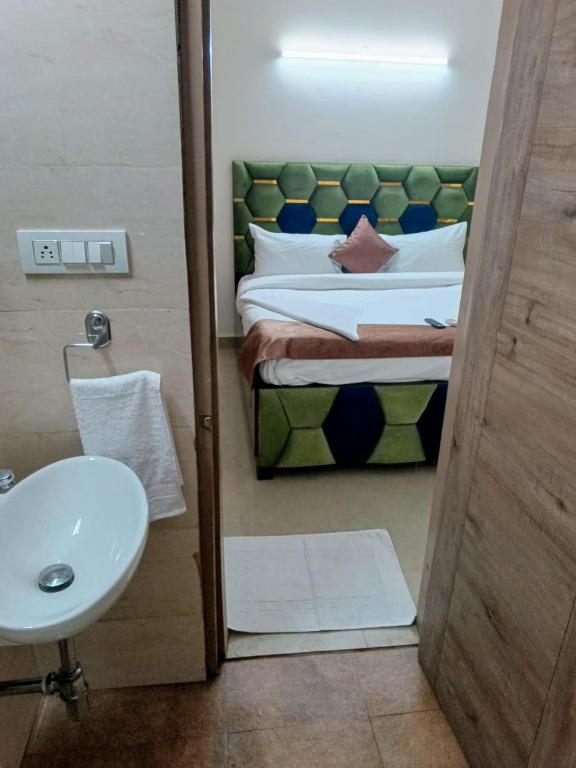 bagno con letto, lavandino e servizi igienici di Soooper Hotel a Gurgaon
