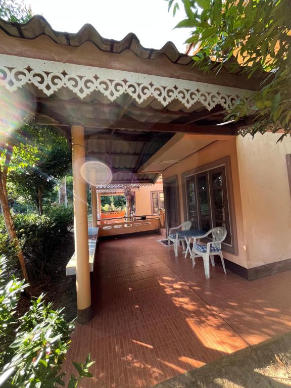 a porch of a house with a table and chairs at Baan Mali Koh Kood in Ban Hin Dam