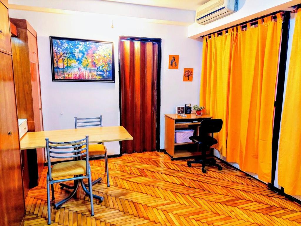 a room with a desk and a table and chairs at Bohemia Baires Balvanera in Buenos Aires