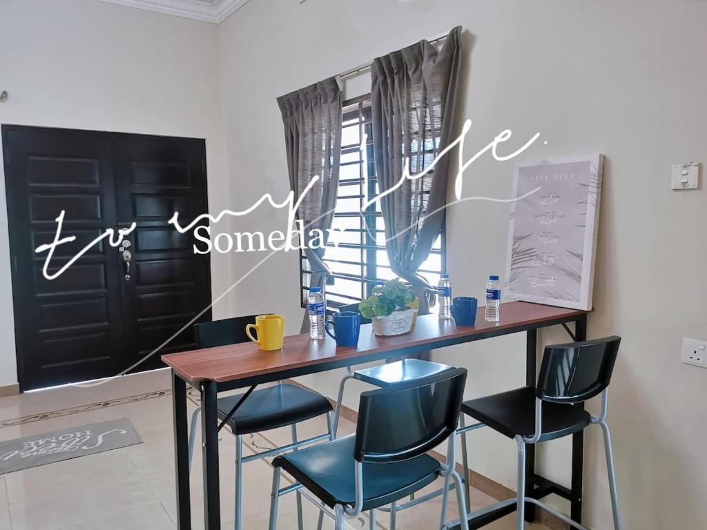 a dining room table with blue chairs and a window at Kuantan Air Putih 4 rooms 3 bathrooms Town area in Kuantan