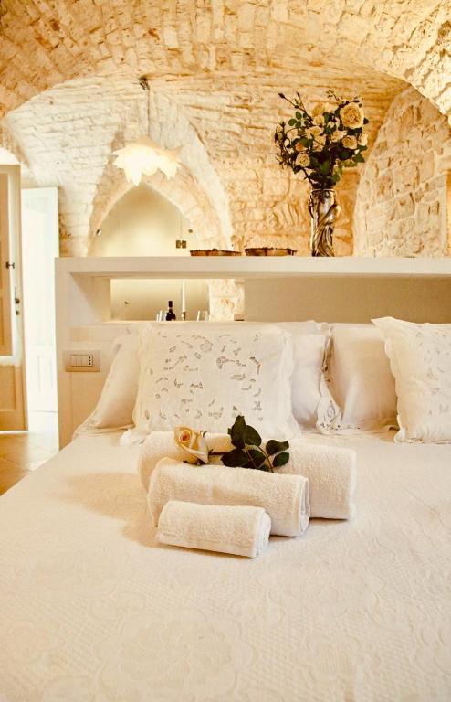 a large white bed with a teddy bear sitting on it at DeaDomus 55 in Cisternino