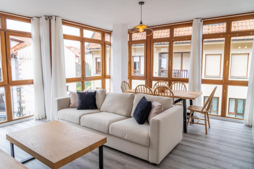 a living room with a couch and a table at Amplio Apartamento en Llanes Centro in Llanes