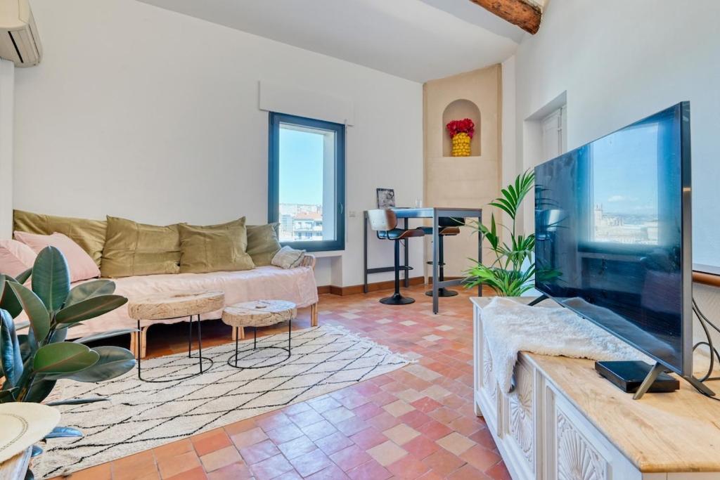 un salon avec une grande télévision à écran plat dans l'établissement T2 duplex climatisé à Endoume vue Vieux-Port, à Marseille