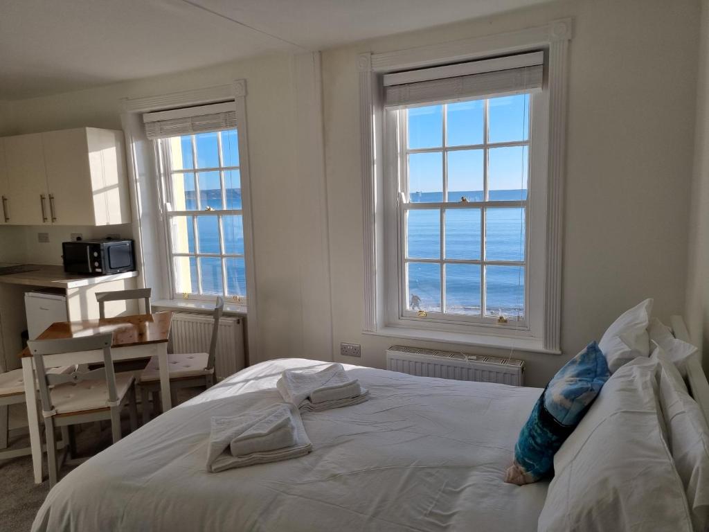 ウェイマスにあるHorizon Sea View Suiteのベッドルーム1室(白いベッド1台、窓2つ付)