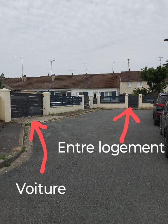 un parking avec deux flèches rouges et les mots d'entrée dans l'établissement Maison au calme chez stephane, à Boran-sur-Oise