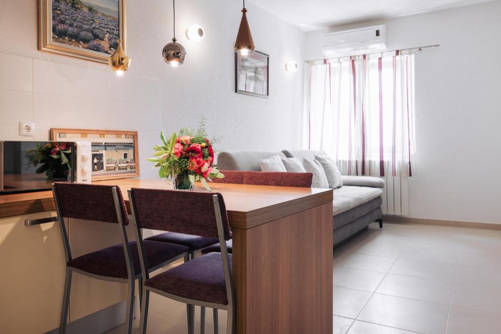 een keuken en woonkamer met een tafel en stoelen bij Center Brela Apartment in Brela