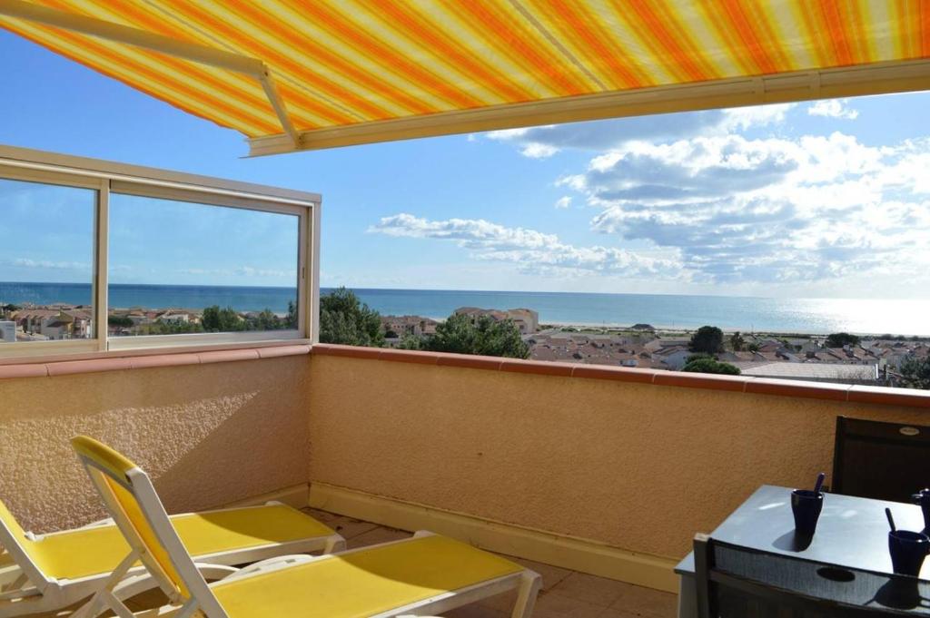 Cette chambre dispose de chaises jaunes et d'une grande fenêtre. dans l'établissement SP450-052 Mais 3 pièces 6 couchages SAINT PIERRE LA MER, à Saint Pierre La Mer