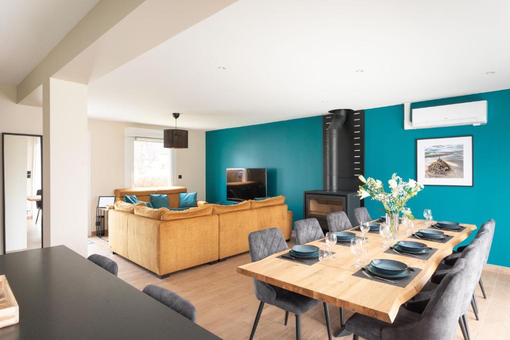 ein Esszimmer mit Tisch und Couch in der Unterkunft Chez Lisette - Maison climatisée dans Cancale in Cancale