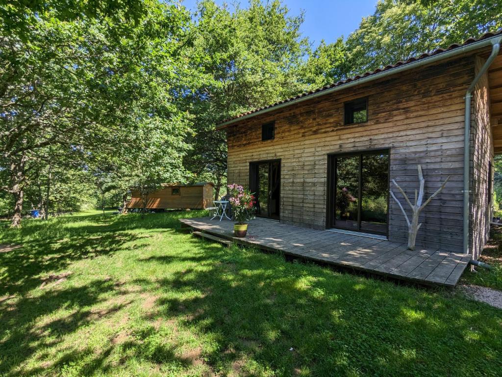 une arrière-cour d'une maison avec une terrasse en bois dans l'établissement Chambre d'Art, à Friaudour