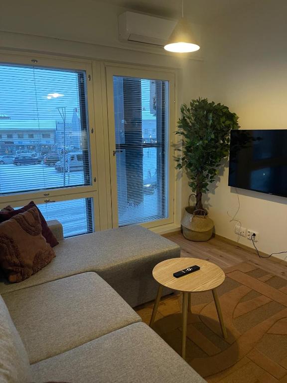 a living room with a couch and a tv and a table at Aurora suites with AIR CONDITIONING in Rovaniemi