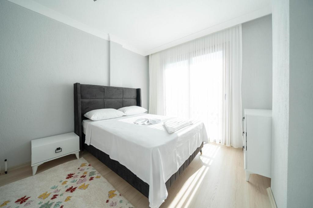 a white bedroom with a large bed and a window at Villa Türkoğlu Akyaka Kuyucak Daily Weekly Rentals in Mugla