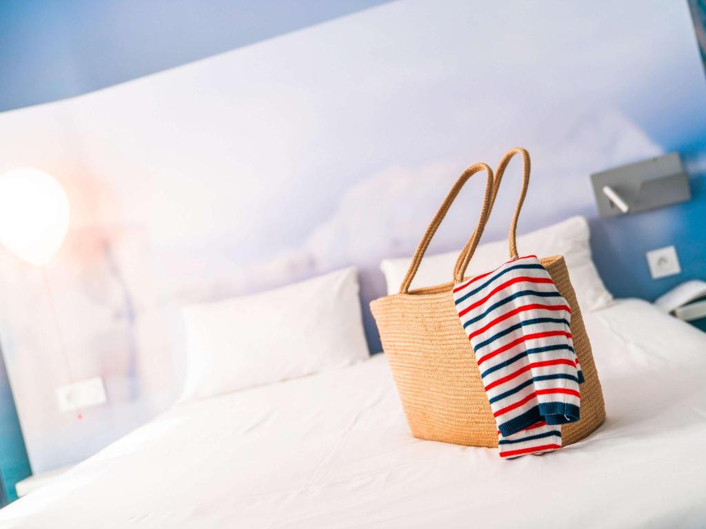 a basket bag sitting on top of a bed at ibis Styles Toulon Centre Port in Toulon