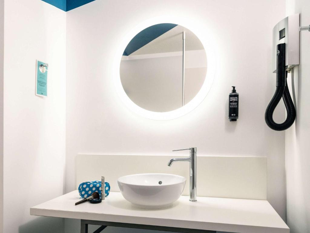 a white bathroom with a sink and a mirror at ibis Styles Toulon Centre Port in Toulon