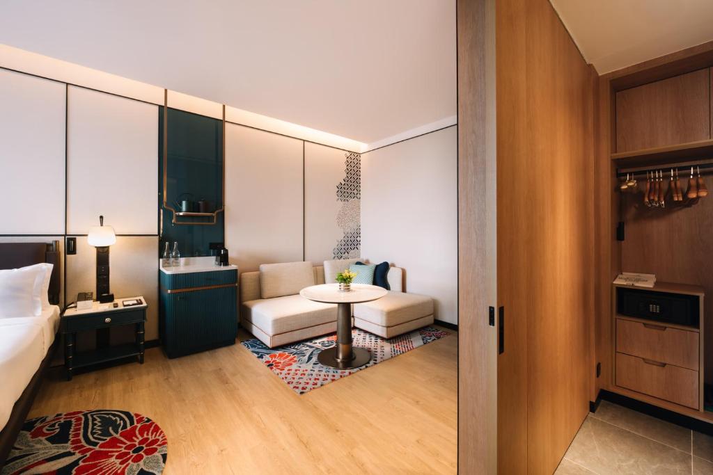 峇六拜Iconic Marjorie Hotel, Penang, a Tribute Portfolio Hotel的配有床、桌子和沙发的房间