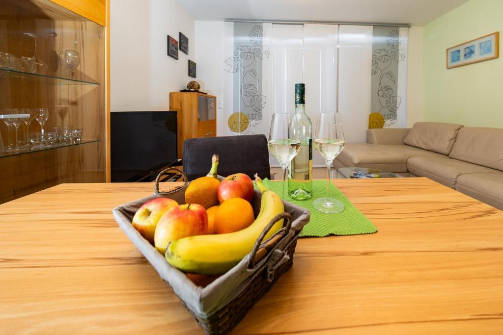 a basket of fruit on a table with wine glasses at Appartement Klosterhügel in Haus im Ennstal