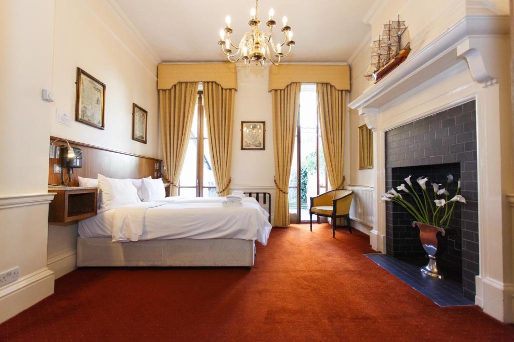 um quarto com uma cama e uma lareira em Morgan Hotel em Londres