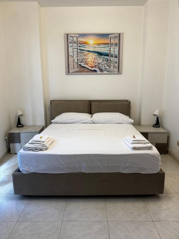 a bed in a bedroom with a picture on the wall at Residenza Dartuffo - Apartment - City Centre in Scilla