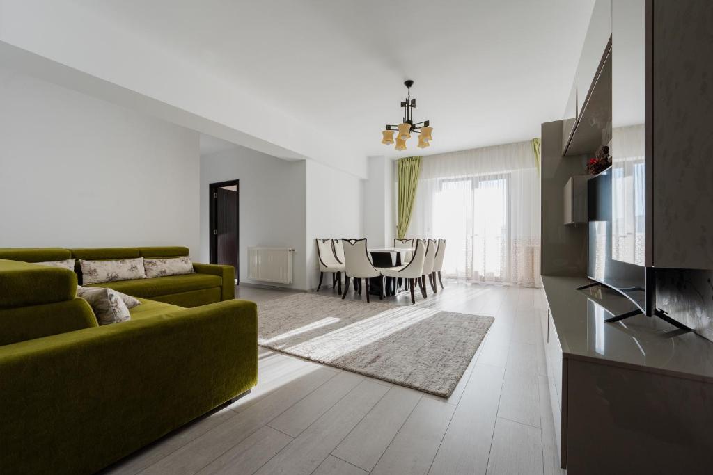 a living room with a green couch and a table at Luxury Apartment in Râmnicu Vâlcea