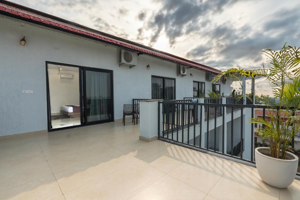 a balcony of a house with glass doors at Corbett Tusker Meadows by White Flower in Rāmnagar